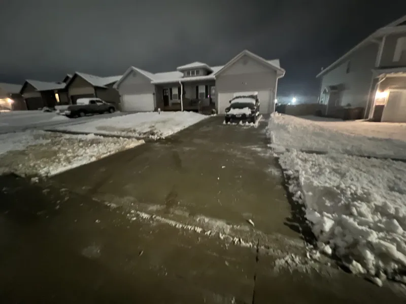Residential snow removal clearing driveway and sidewalk in West Des Moines Iowa winter