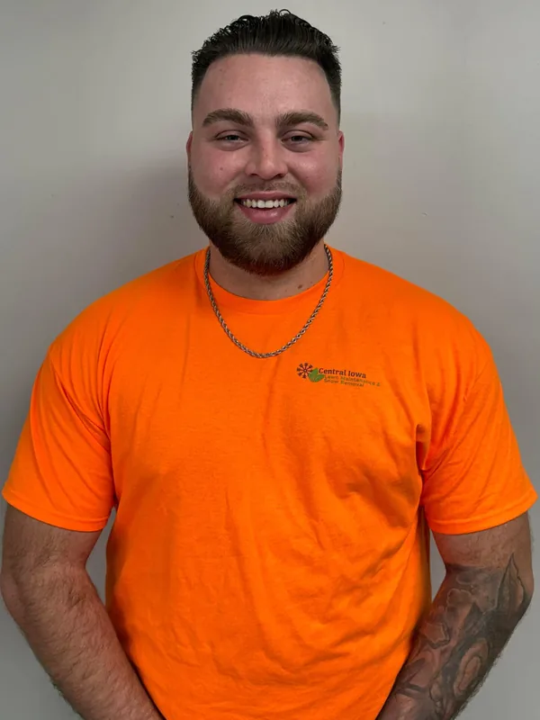 Zach Frye, owner of Central Iowa Lawn Maintenance and Snow Removal, wearing the company's branded orange work shirt